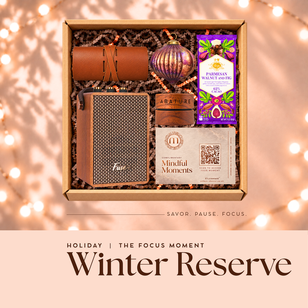 Winter Reserve holiday engagement kit, open gift box with Bluetooth speaker, leather tech roll, lip butter, glass ornament and chocolate bar