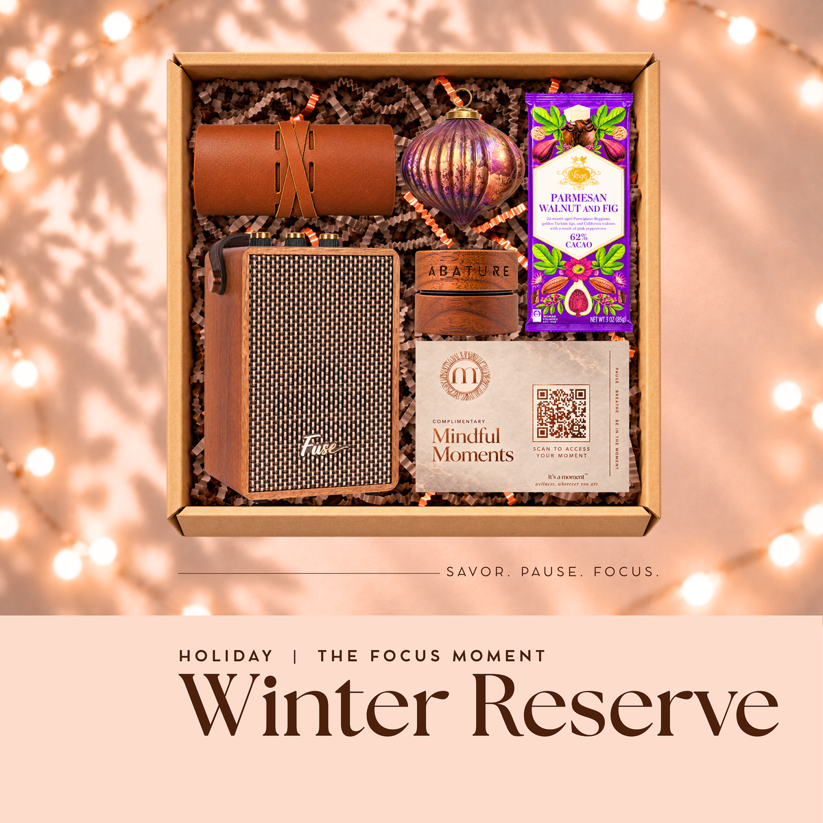 Winter Reserve holiday engagement kit, open gift box with Bluetooth speaker, leather tech roll, lip butter, glass ornament and chocolate bar